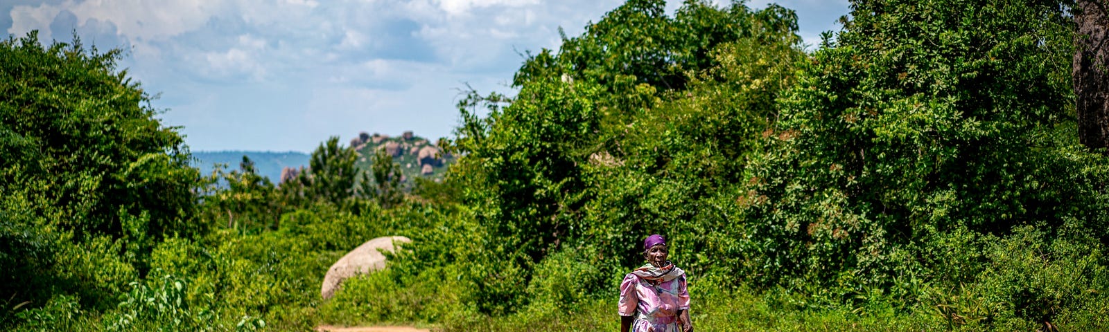 Woman walking on a dirt road.