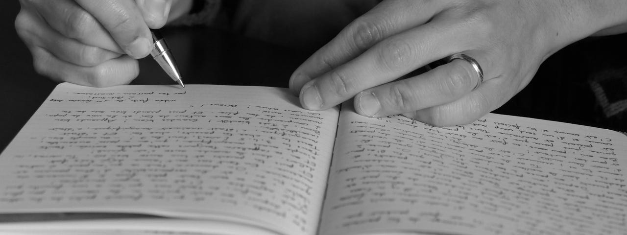 Hands writing on a healing journal.