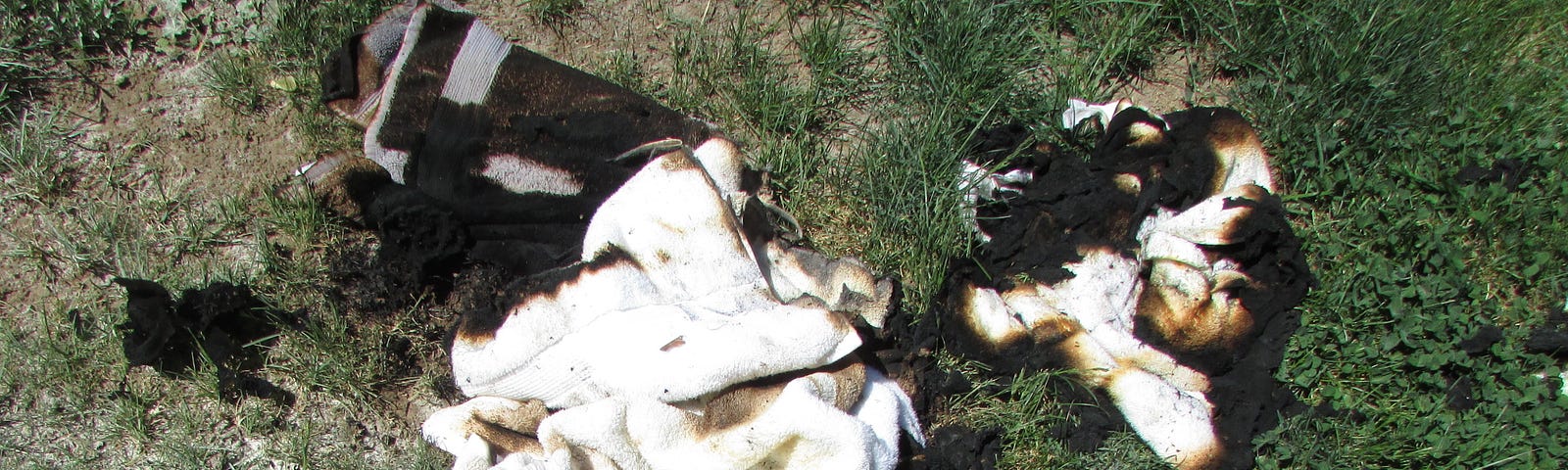 Pile of burnt towels in yard