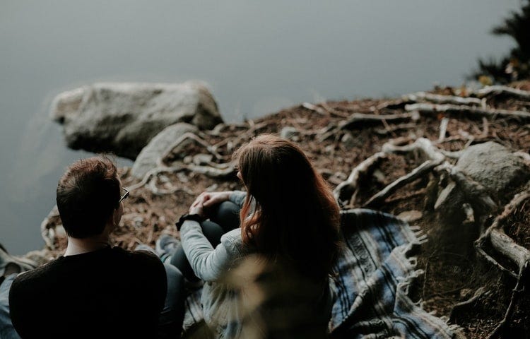 couple sitting near the water