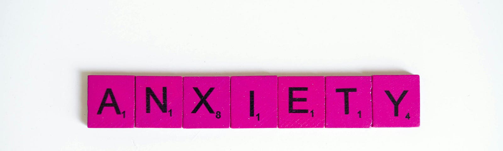 Anxiety spelled out in hot pink Scrabble letters