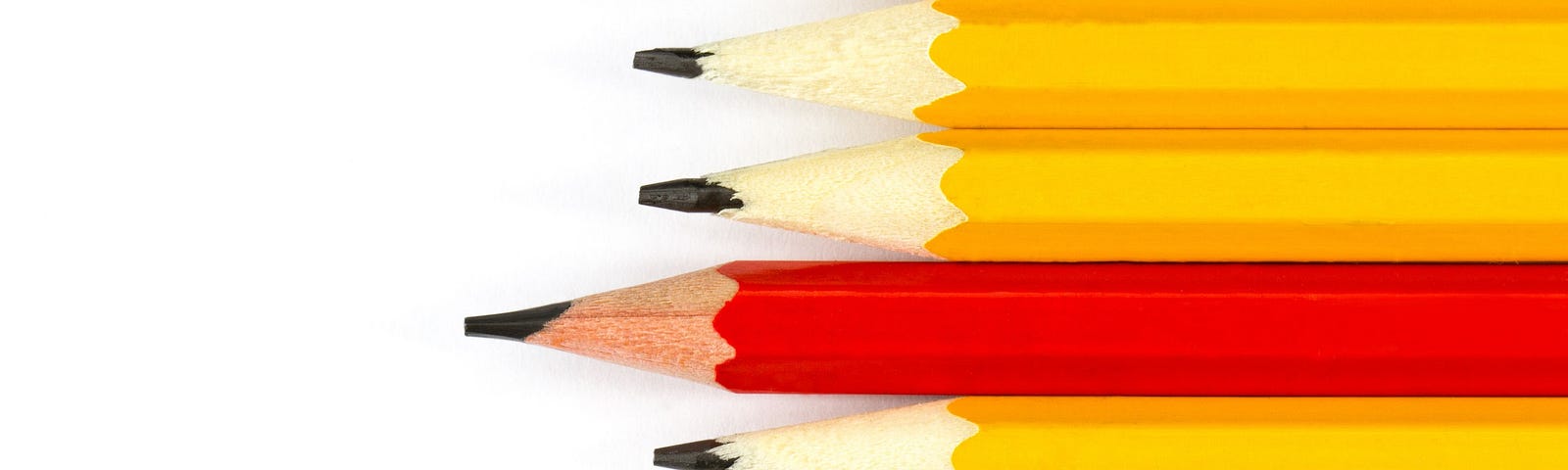 Row of yellow pencils with red pencil for proofreading in the middle