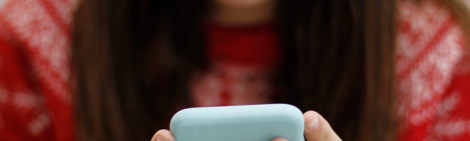 A young person using their phone.