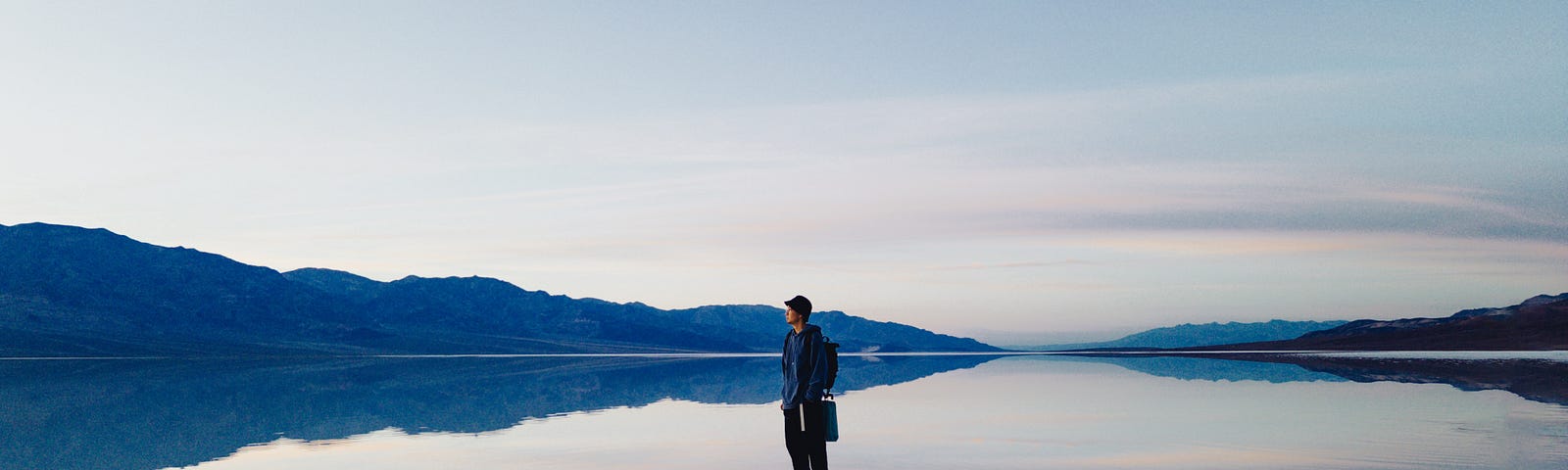 A man standing in the middle of a shallow lake