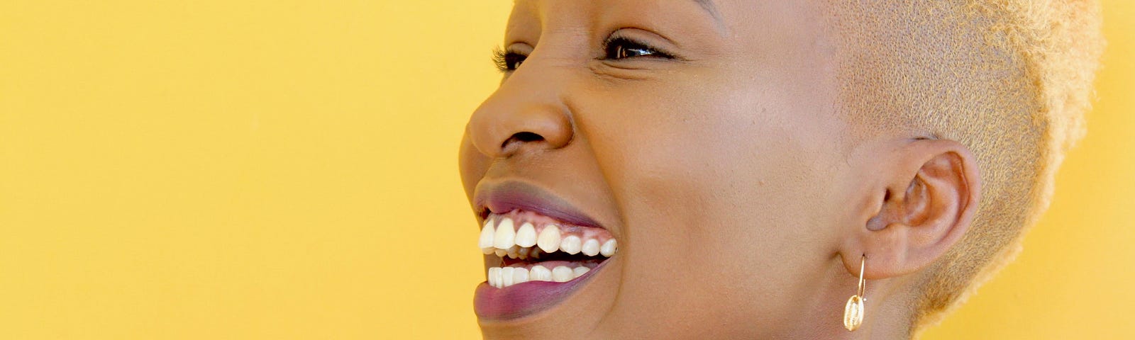 Black woman with short blond hair laughing