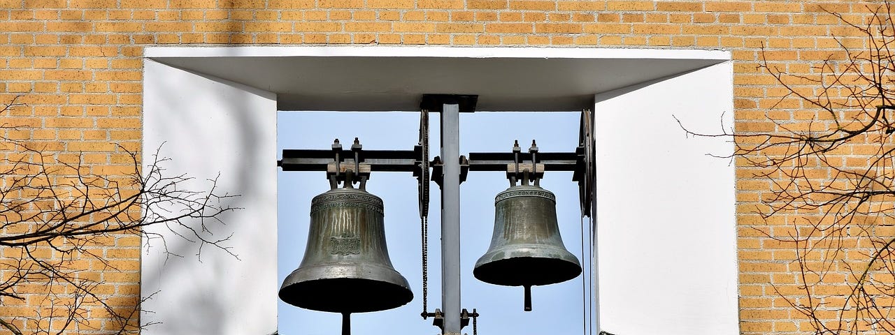 Church bells through window in wall.