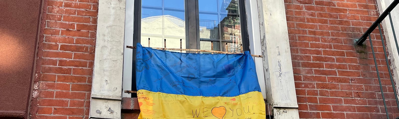 Photo of the Ukrainian Flag in a window in the Little Ukraine neighborhood of the East Village of New York.