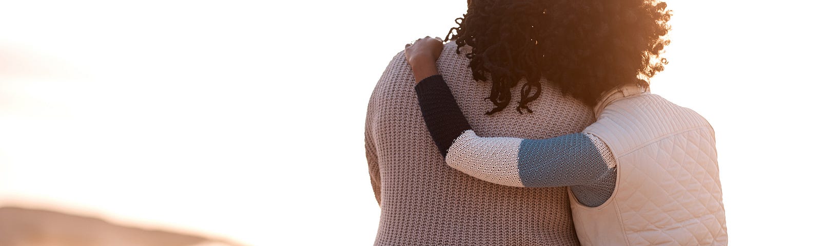 two people hugging on a beach