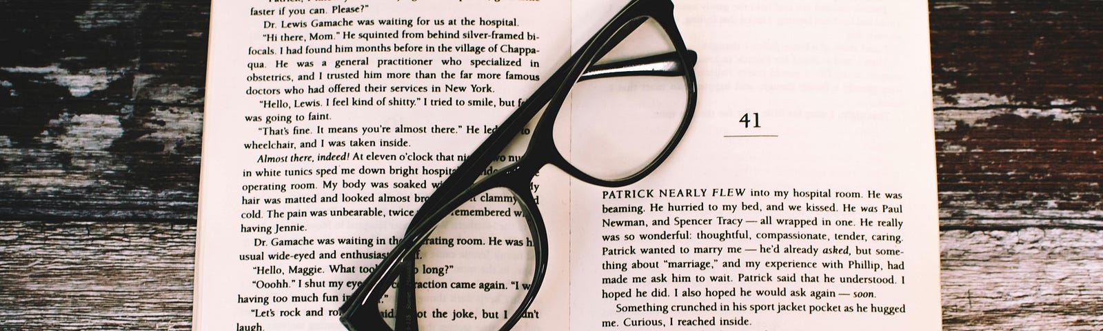 A pair of glasses on an open book.