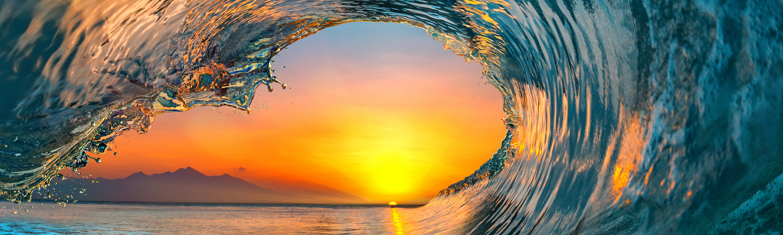 a sunset inside an ocean’s wave