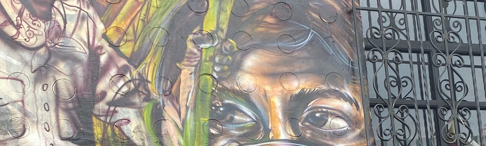 A mural in downtown Cali, which depicts a woman with a mask