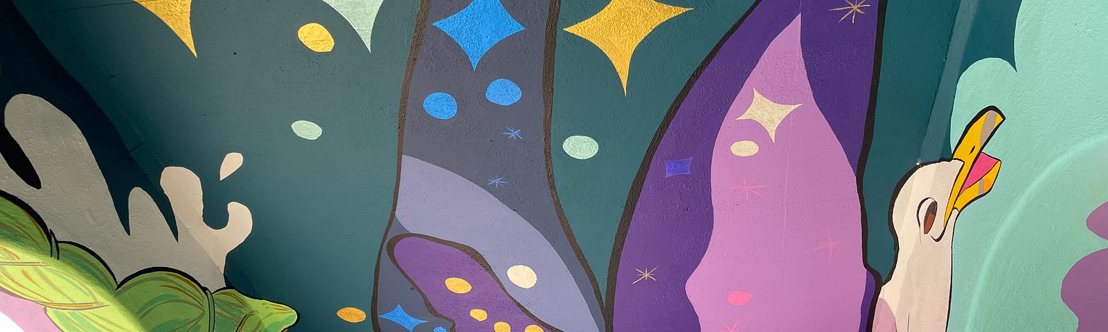 A mural, shown painted onto a ceiling. It has a mix of colors (purple, blue, white, yellow, red, green), shapes (stars, circles), and figures (a seagull, coral).