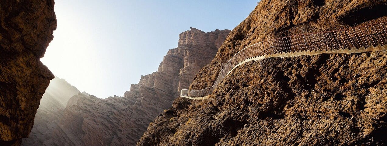 Picture of a long set of stairs up the side of a mountain that looks impossible to climb.