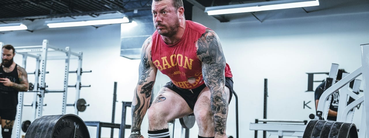 A man attempting to life a heavy barbell