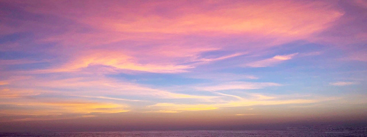 The ocean at dusk with a blue and pink sky.