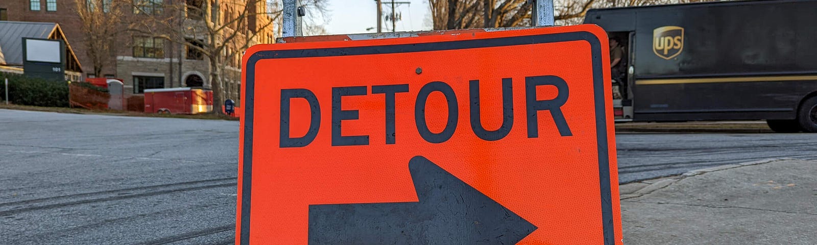 Orange Detour sign with large black arrow