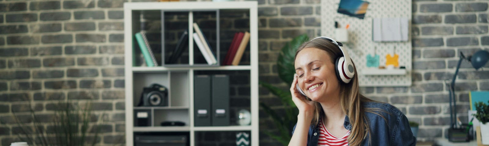 A young woman on a teleconference call with a headset and laptop computer