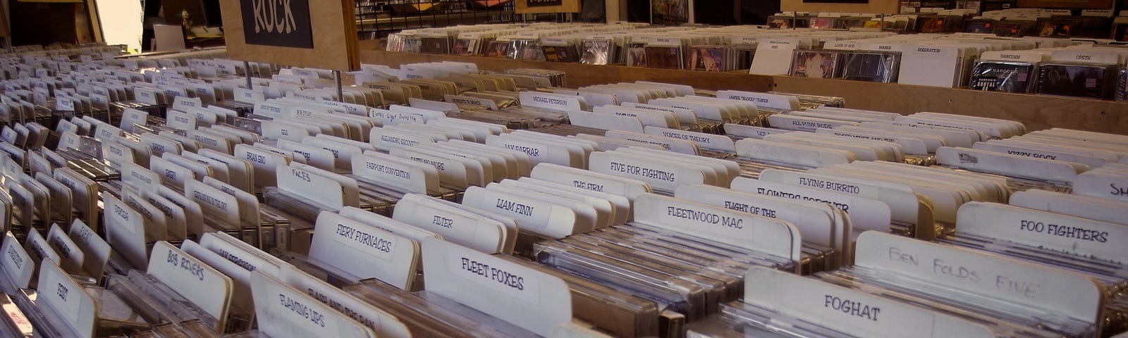 Photo of endless bins of rock LPs, cateogries by tabs in a record store.