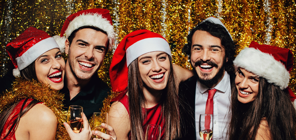 People in Santa hats celebrating at a holiday party