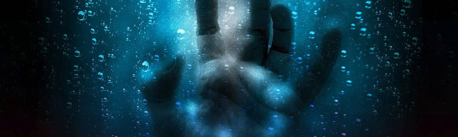 A hand shown pressing through blue glass in the rain