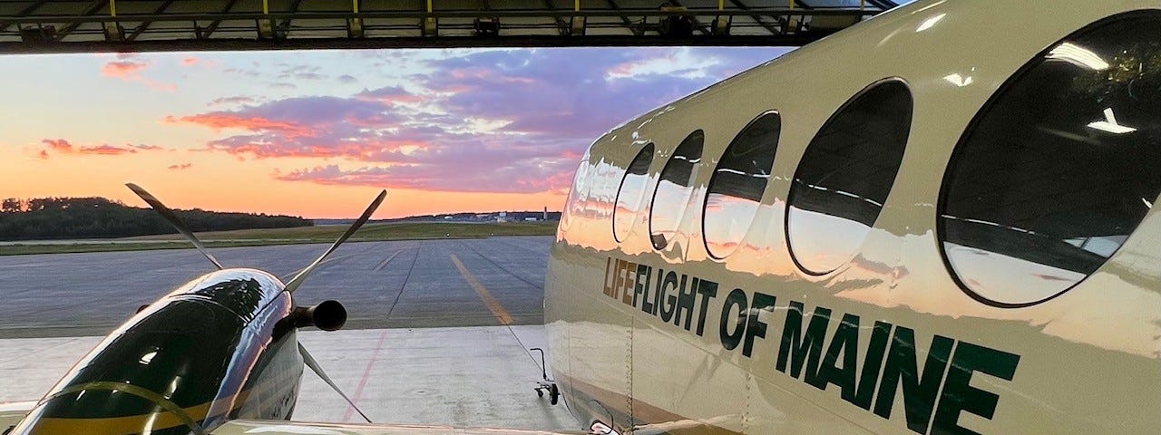 An aircraft in the hangar at sunset with “LifeFlight of Maine” on the side.