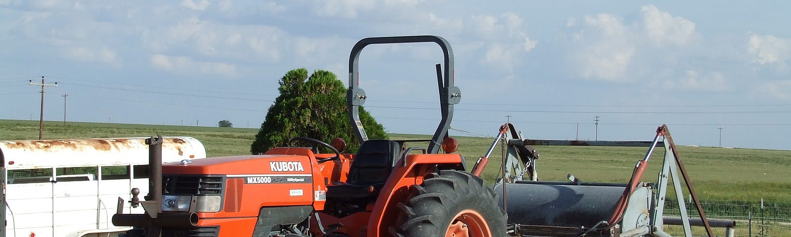 Image of an orange coloured tractor and farm implements on a New Mexico farm