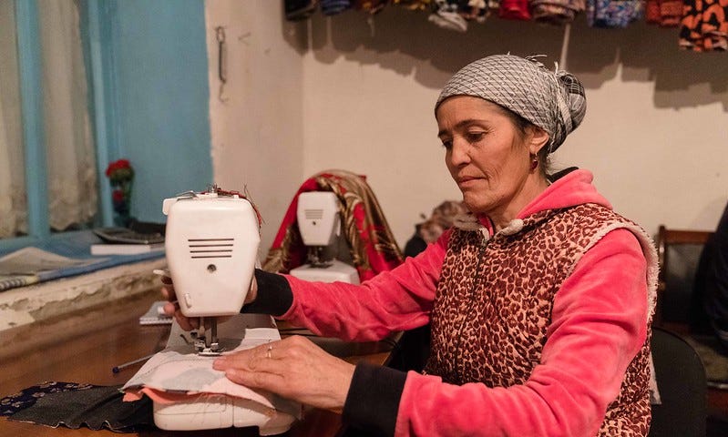 Roziyamo Kabirova sits in front of her sewing machine