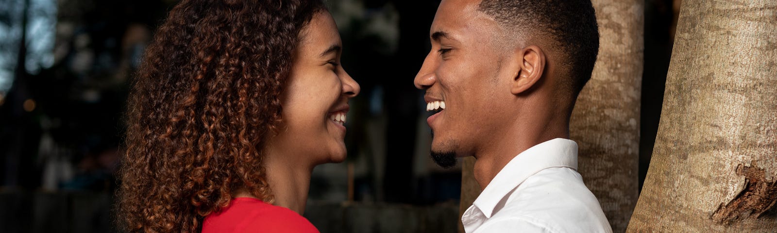 A man and woman staring into each other’s eyes outside.