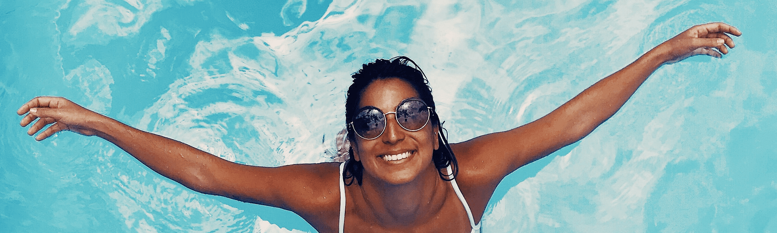 A woman in a pool, smiling… likely because she’s practicing these consumption habits.