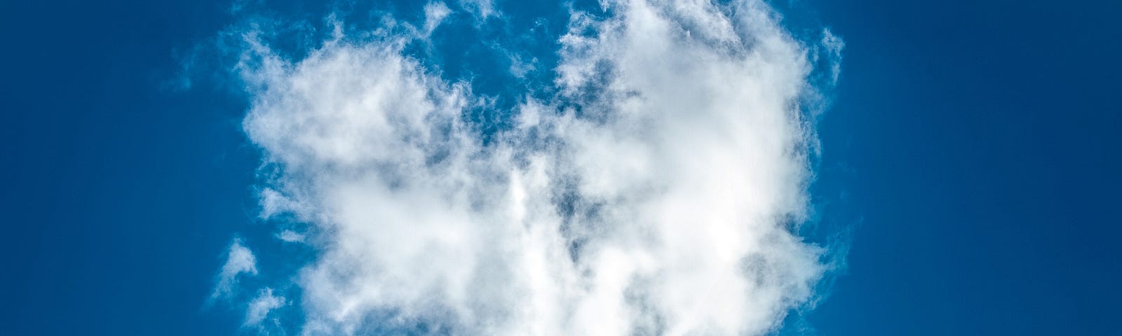 Heart-shaped white cloud against a blue sky.