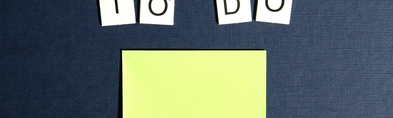 Letter tiles arranged to spell “to do” on top of a blank post-it note