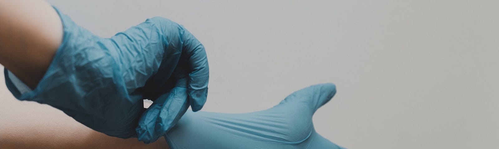 A pair of hands wearing blue medical gloves