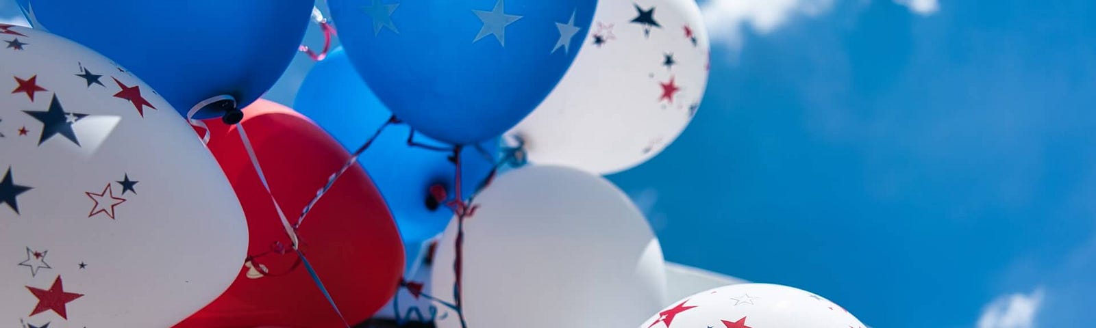 United States Flag with blue, red, and white balloons celebrating the American Independence Day on 4th of July