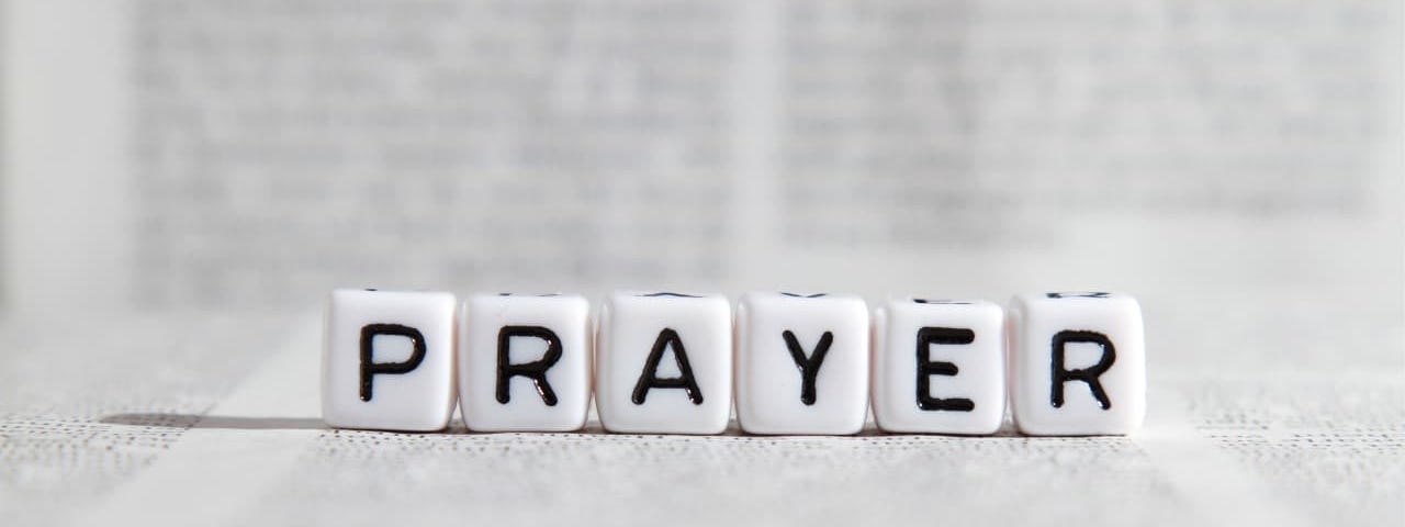 the word “prayer” spelled by Scrabble letters