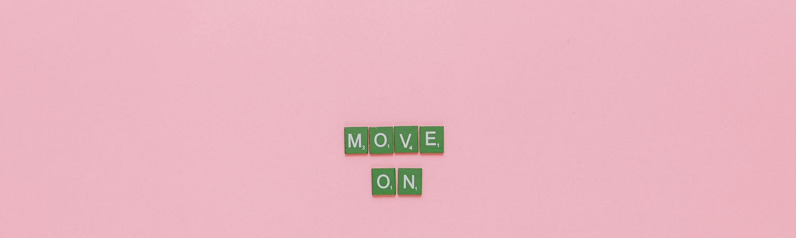 Very small, against a pink background, the words “Move On,” spelled out in Scrabble-type tiles.