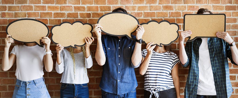 Group of people holding up cardboard speech bubbles