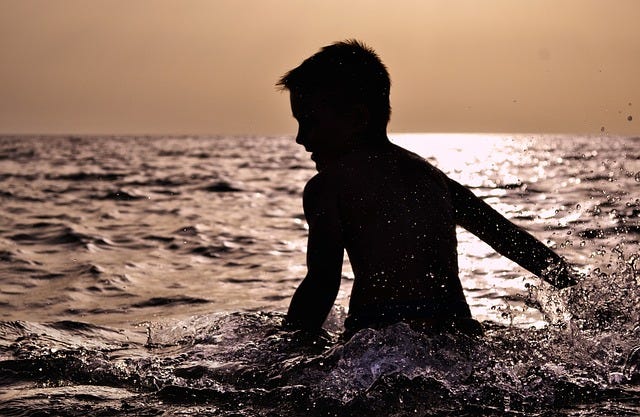 A boy splashing around in the sea