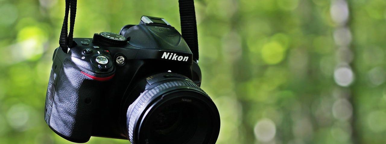 IMAGE: A Nikon DSLR camera hanging from its strap