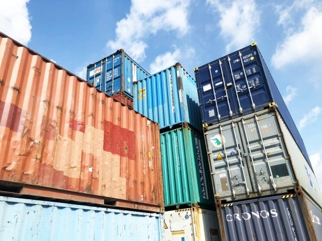 An assortment of colorful shipping containers, blue sky in background