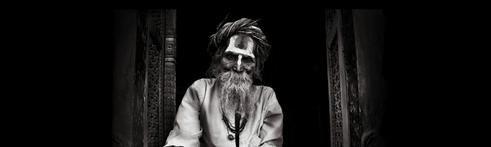 Alice Kim’s Soulful Art. Black and white portrait of an old sadhu sitting in lotus position