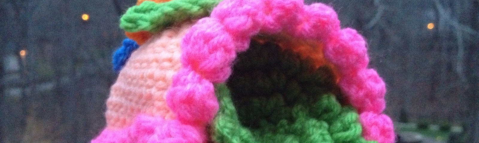 A crochet sugar egg with crochet flowers, trim, and grass