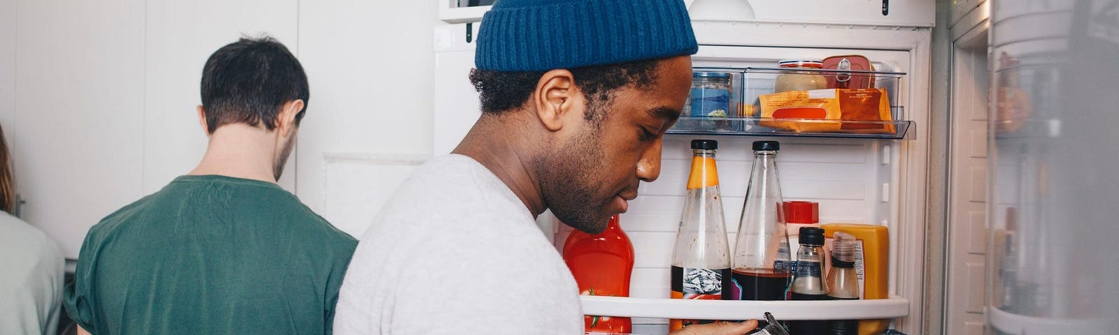 Man checking date of food in fridge.