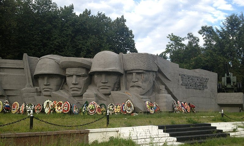 A memorial with the faces of four men carved into concrete