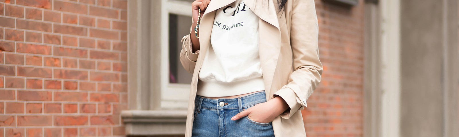 A young lady putting on a knee length jacket, a waist length jacket paired with a skinny jeans