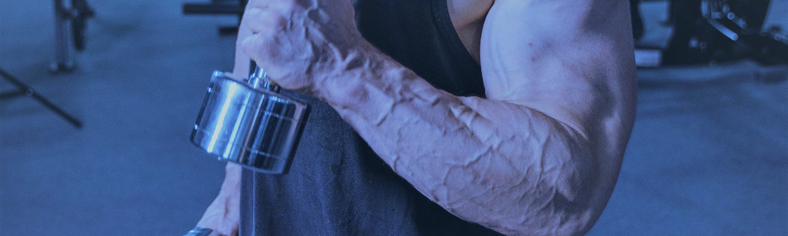 a male hammer curling a dumbbell, with large forearms