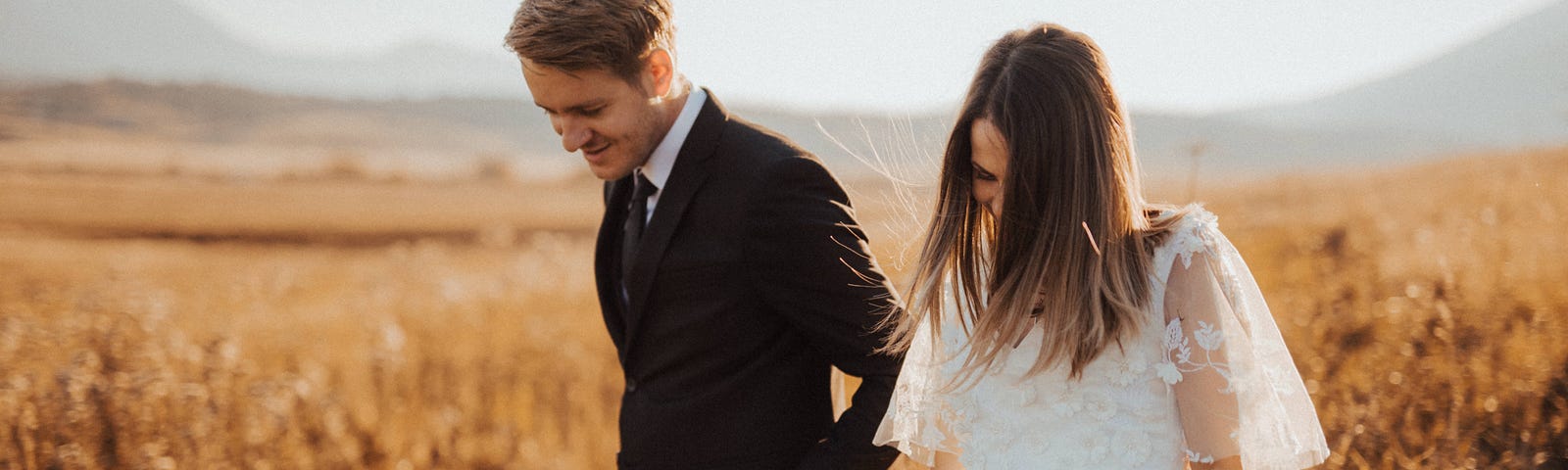 A couple holding hands in a field