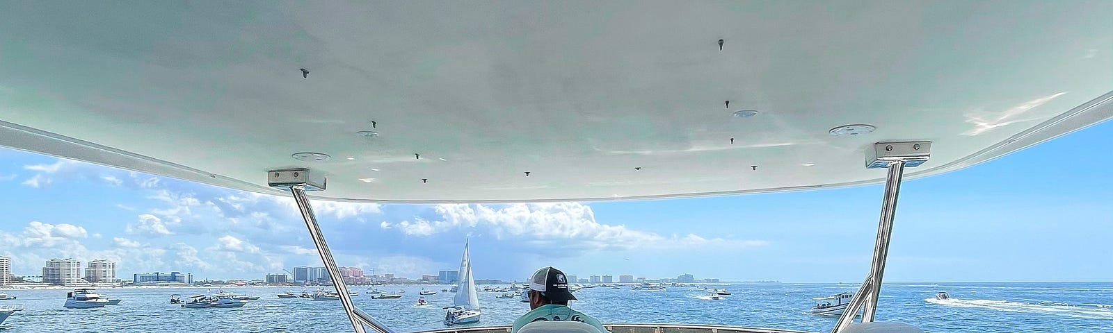 The captain of the ship sits at the top deck of the boat and navigates the way to the powerboat race track.