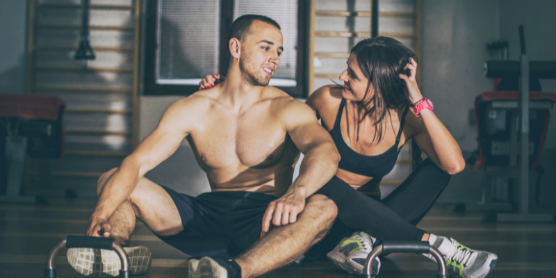 Man and woman sitting on the ground after working out — 5 fat loss myths debunked by science