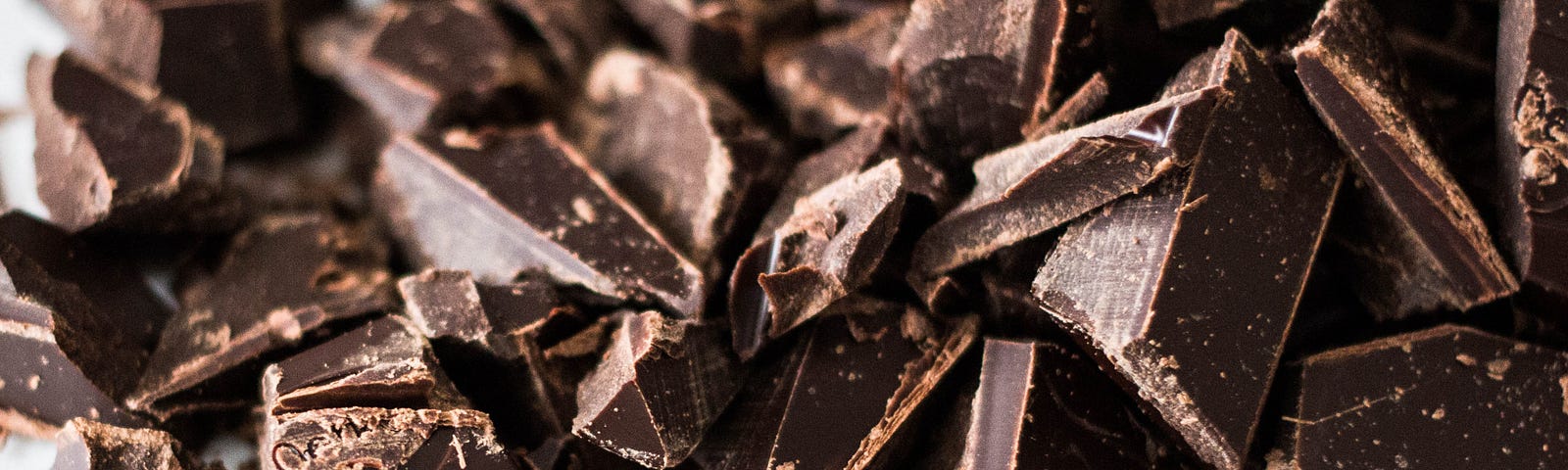 A close up of cut up chocolate on a white table.