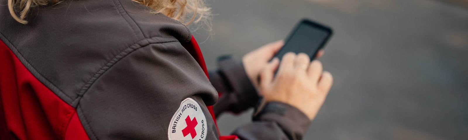 British Red Cross Volunteer checking their mobile phone